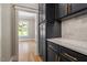A modern kitchen features dark cabinets with gold hardware and marble countertops, with wood floors at 3934 Old Chapel Hill Rd, Durham, NC 27707