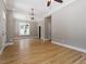 A spacious living room features recessed lighting, a modern chandelier, and beautiful wood floors at 3934 Old Chapel Hill Rd, Durham, NC 27707