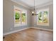 An airy living room features natural light from two windows and beautiful wood floors at 3934 Old Chapel Hill Rd, Durham, NC 27707