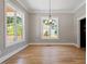 An airy living room features natural light from two windows and beautiful wood floors at 3934 Old Chapel Hill Rd, Durham, NC 27707