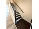 The beautiful staircase features a dark wood trim with white risers and luxury vinyl plank flooring at 408 La Maison Ave # 3, Wendell, NC 27591