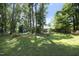 Large backyard with mature trees and grass area at 409 Glaive Dr, Durham, NC 27703