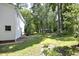 Side of home and patio area with big backyard and mature trees at 409 Glaive Dr, Durham, NC 27703