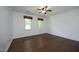 Large bright bedroom featuring hardwood floors, ceiling fan, and two large windows at 409 Glaive Dr, Durham, NC 27703