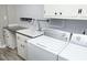 Spacious laundry room with modern washer and dryer and sink basin at 409 Glaive Dr, Durham, NC 27703