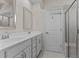 Clean and well-lit bathroom with a double vanity, framed mirror, and glass shower door at 417 Austin View Blvd, Wake Forest, NC 27587