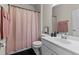 Pretty bathroom features a single sink, neutral wall color, and a bathtub with pink shower curtain at 417 Austin View Blvd, Wake Forest, NC 27587