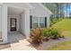Close-up of the front entrance showing a cozy porch with decorative columns and a well-maintained garden at 418 Ivy Bank Dr, Angier, NC 27501