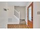 Bright entryway with wood-look flooring, a staircase with white railings, and a decorative front door at 4309 Birmingham Way, Raleigh, NC 27604