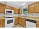 The kitchen showcases matching white appliances and lots of cabinetry at 4309 Birmingham Way, Raleigh, NC 27604