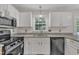 Bright kitchen features granite countertops, stainless steel appliances, and white cabinets at 4309 Birmingham Way, Raleigh, NC 27604