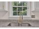 Close-up of kitchen sink area features granite countertops and stainless steel appliances at 4309 Birmingham Way, Raleigh, NC 27604