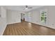Bright living room with wood-look floors, a ceiling fan, and large windows offering a view of the exterior at 4309 Birmingham Way, Raleigh, NC 27604