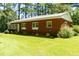 Traditional brick ranch with green lawn and mature trees offers classic curb appeal at 452 N Main St, Wendell, NC 27591