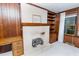 Cozy living room with whitewashed brick fireplace, wood paneling, and built-in shelves at 452 N Main St, Wendell, NC 27591