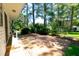 Expansive paver patio surrounded by lush greenery, mature trees and manicured landscaping at 452 N Main St, Wendell, NC 27591
