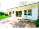 Paver patio with sliding glass doors leading to a white home with trees and manicured landscaping in the background at 452 N Main St, Wendell, NC 27591