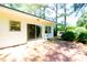 Paver patio with sliding glass doors leading to a white home with mature trees and manicured landscaping at 452 N Main St, Wendell, NC 27591