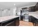 Spacious kitchen with stainless steel appliances, dark cabinets, white countertop and an island with seating at 46 Bellini Dr, Angier, NC 27501