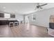 Spacious living room with wood-look flooring, ceiling fan, and sliding glass doors to the backyard at 46 Bellini Dr, Angier, NC 27501
