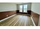 Bright bedroom with hardwood floors, with two windows, and brown paneling halfway up walls at 48 Firefly Ln, Fuquay Varina, NC 27526