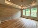 Spacious living room with hardwood floors, tile accent wall, a chandelier, and many windows at 48 Firefly Ln, Fuquay Varina, NC 27526