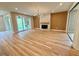 Spacious living room with a fireplace, wood accent wall, hardwood floors, and sliding glass doors at 48 Firefly Ln, Fuquay Varina, NC 27526