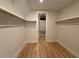 Walk-in closet with hardwood floors, shelving and a door at the end of the hallway at 48 Firefly Ln, Fuquay Varina, NC 27526