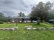 Brick house with a front porch and front yard with unique concrete block border and tall shade tree at 503 Adams St, Henderson, NC 27536