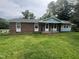 Charming brick home featuring a covered front porch, updated trim, and freshly mowed lawn at 503 Adams St, Henderson, NC 27536