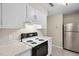 Well-lit kitchen features white cabinets, marble countertops, and modern appliances at 5082 Flint Ridge Pl, Raleigh, NC 27609