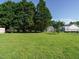 Large backyard with lush grass, mature trees, storage building, and privacy fence at 516 Yellow Berry, Wendell, NC 27591
