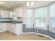 Bright eat-in kitchen with a bay window, laminate floors, and white cabinetry at 516 Yellow Berry, Wendell, NC 27591