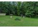 Expansive backyard with lush greenery, a playhouse, and a storage shed, perfect for outdoor activities at 5307 Green Riley Rd, Rougemont, NC 27572