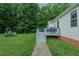 Backyard view showcasing the deck, stairs, and mature trees at 5307 Green Riley Rd, Rougemont, NC 27572