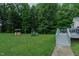 Lush backyard featuring a well, playset, and a deck with stairs at 5307 Green Riley Rd, Rougemont, NC 27572