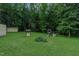 Expansive backyard with lush greenery, playset, a well, and storage shed at 5307 Green Riley Rd, Rougemont, NC 27572