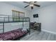 A bedroom with gray vinyl floors, a bunk bed, a ceiling fan, a window, and a dresser at 5307 Green Riley Rd, Rougemont, NC 27572