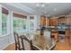 A dining room boasts ample natural light, complemented by a kitchen view and wood flooring at 5307 Green Riley Rd, Rougemont, NC 27572