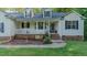 Inviting home exterior with a charming porch, complemented by lush green lawn and mature trees at 5307 Green Riley Rd, Rougemont, NC 27572