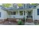 Traditional home with a welcoming front porch, brick accents, and lush landscaping at 5307 Green Riley Rd, Rougemont, NC 27572