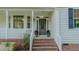 Inviting front porch with brick steps, decorative plants, and white railings enhance curb appeal at 5307 Green Riley Rd, Rougemont, NC 27572