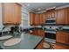 Cozy kitchen featuring wooden cabinetry, dark countertops, and stainless steel appliances at 5307 Green Riley Rd, Rougemont, NC 27572