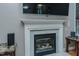Close-up of the fireplace and TV in the living room with marble surround and details at 5307 Green Riley Rd, Rougemont, NC 27572