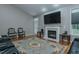 Cozy living room featuring a fireplace, large TV, hardwood floors, comfortable seating, and ceiling fan at 5307 Green Riley Rd, Rougemont, NC 27572