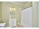 Bathroom with white vanity, neutral tile floors, shower with curtain and updated lighting at 5328 Willow Cry Ln, Raleigh, NC 27613