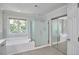 Bright bathroom features a soaking tub under a window and a glass shower at 5328 Willow Cry Ln, Raleigh, NC 27613