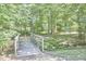 Scenic view of a wooden bridge in a serene, wooded setting at 5328 Willow Cry Ln, Raleigh, NC 27613