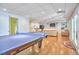 Open game room with ping pong table, seating area, wet bar, and hardwood floors at 5328 Willow Cry Ln, Raleigh, NC 27613