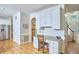 Bright hallway featuring hardwood floors, a built-in desk, white cabinetry, and access to the front entry and the kitchen at 5328 Willow Cry Ln, Raleigh, NC 27613